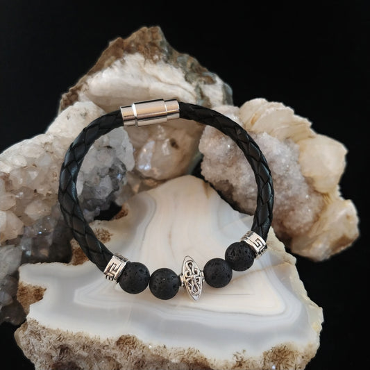Leather bracelet with 4 black lava beads and silver spacers. In the center there is a carm named Eivor with viking symbol. Bracelet sits on a bright agate display stone.