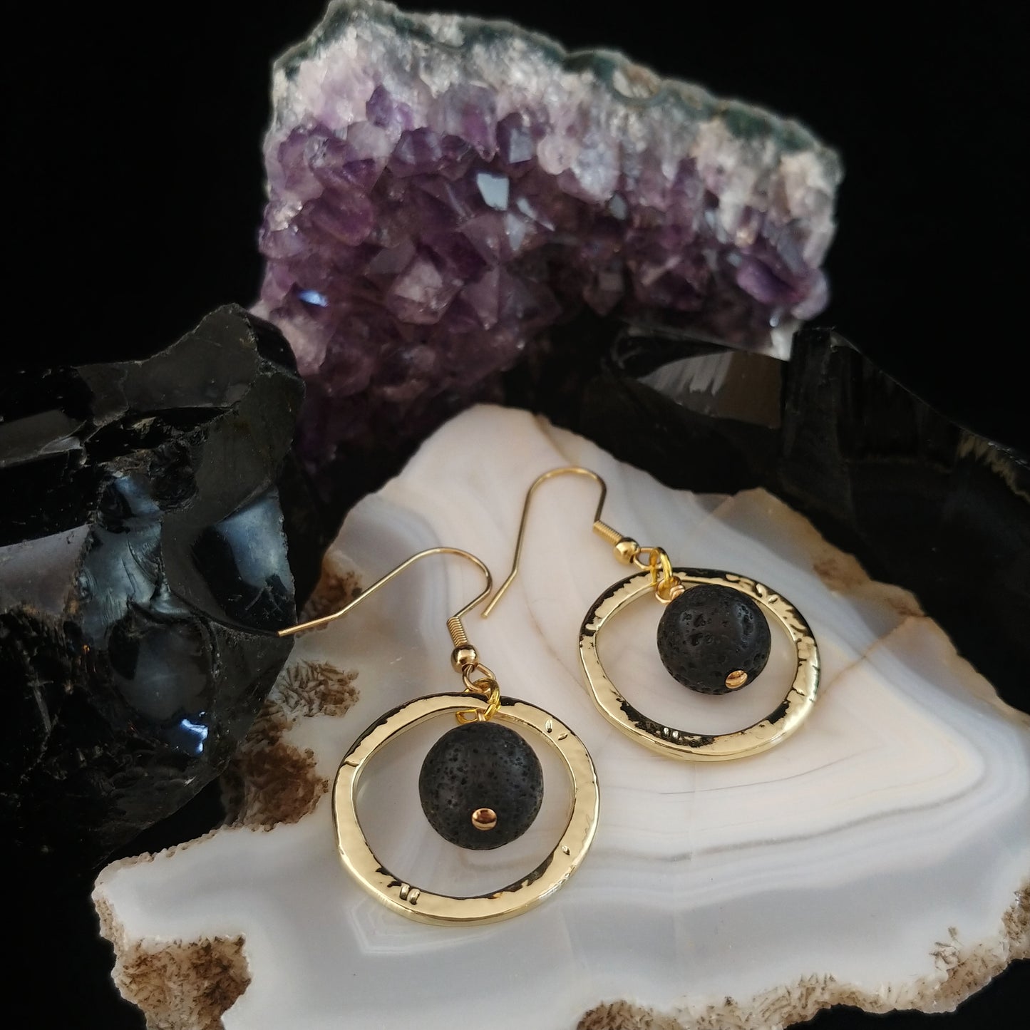 Golden circle earrings with golden alloy ring with black lava beads in the center.